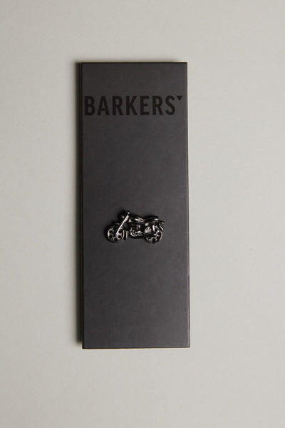 A black Barkers card displays the Motorbike Lapel Pin in gunmetal, shown vertically against a light gray background.