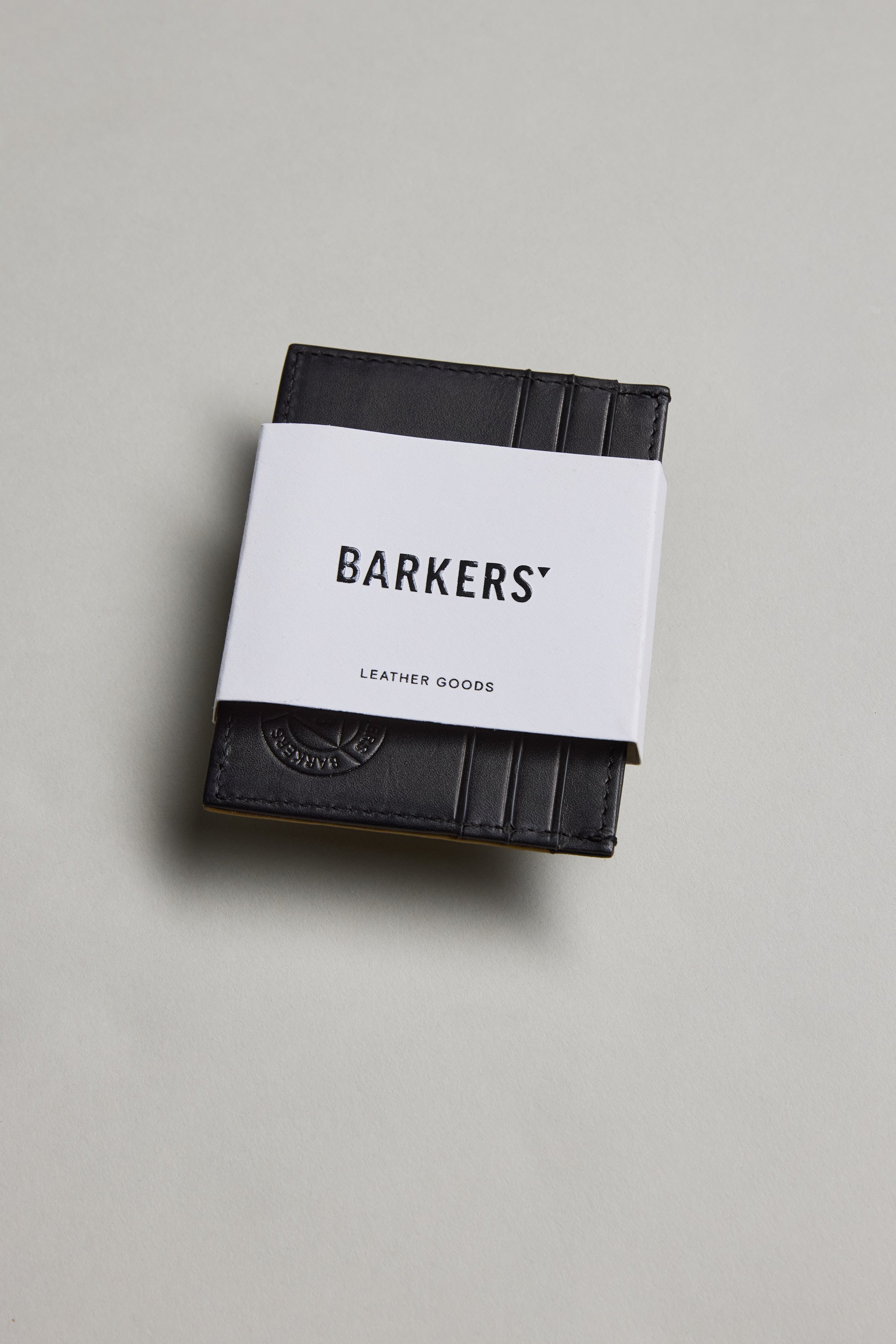 The Taylor Leather Card Wallet by Barkers, wrapped in a white paper band labeled Barkers, is displayed on a light gray surface.