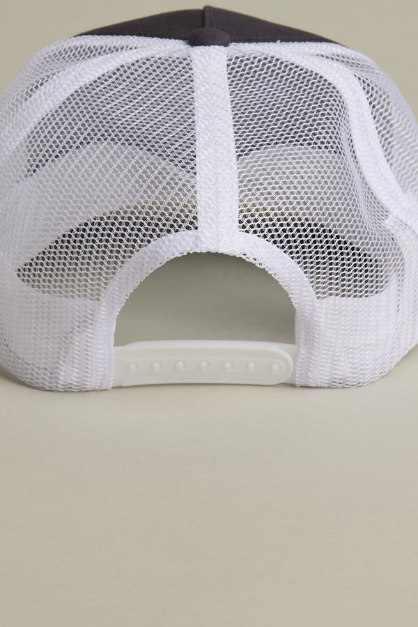 A close-up of the back of the Brixton International Trucker hat by Brixton, showing a white snap closure made from recycled fishing nets, set against a neutral background.