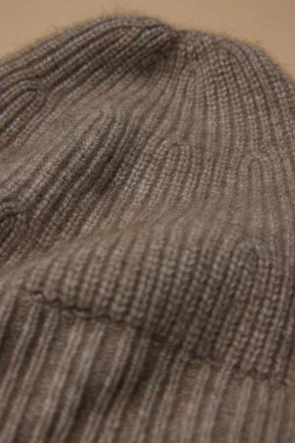 Close-up of ribbed brown knit fabric from the Woolyarns Perino NZ Made Perino Beanie, showing detailed texture and stitches.