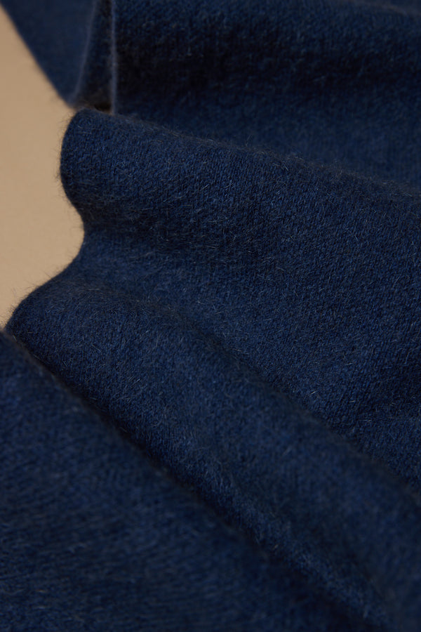 A close-up of soft, dark blue NZ Made Perino Scarf by Woolyarns Perino, showcasing its luxurious merino possum silk blend texture and detailed fibers with a folded edge.