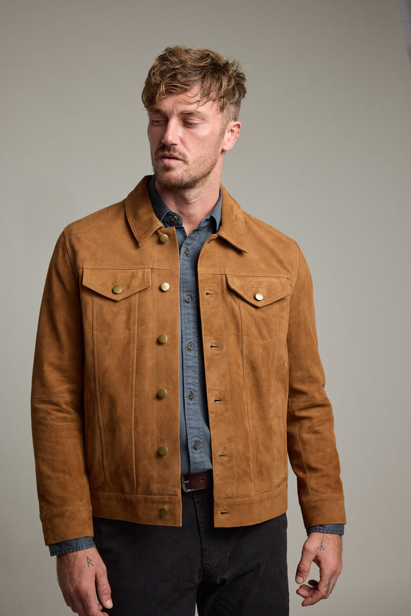 Man wears Barkers Jackson Suede Trucker jacket over a blue shirt, against a plain background.