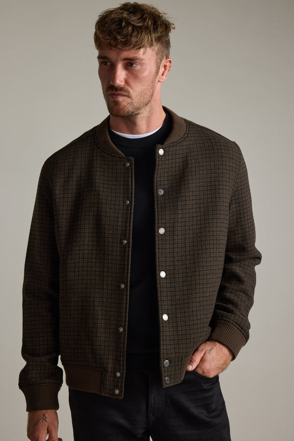Man wears Barkers Leland Wool Bomber Jacket over a black shirt, styled as transeasonal.