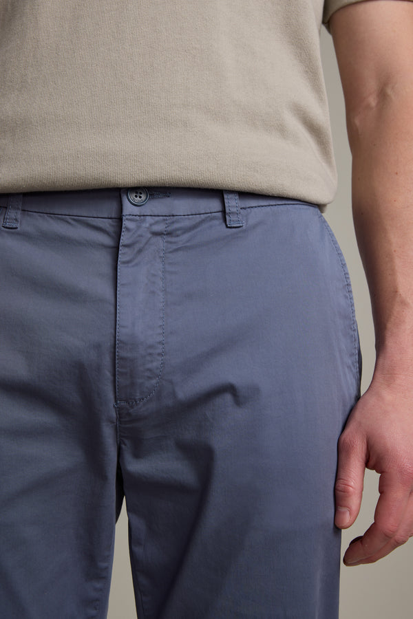 A person wearing a beige short-sleeved shirt and light blue Barkers Kingly Chino Pant stands with their right arm at their side. The image highlights the waist and upper legs, showcasing these summer-ready chinos.