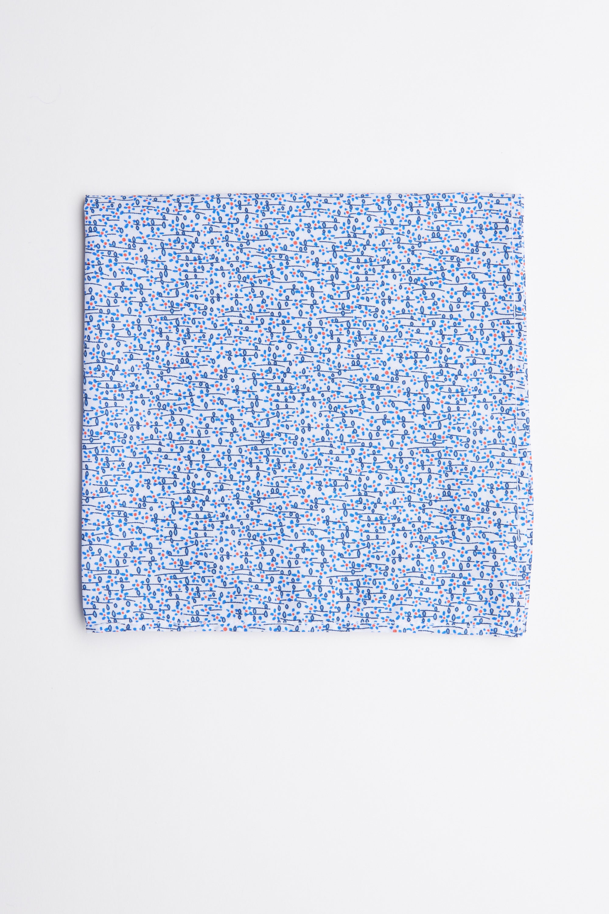 The Barkers Mildred Ditsy Flower Pocket Square features a light blue cotton fabric with small blue and red floral patterns, shown on a plain white background—a sophisticated formal accessory for any suit.