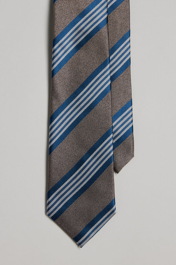 A close-up of the Barkers Frankford Stripe Tie in brown silk, featuring diagonal blue and white stripes on a plain light background—ideal to pair with matching pocket squares or other silk accessories.