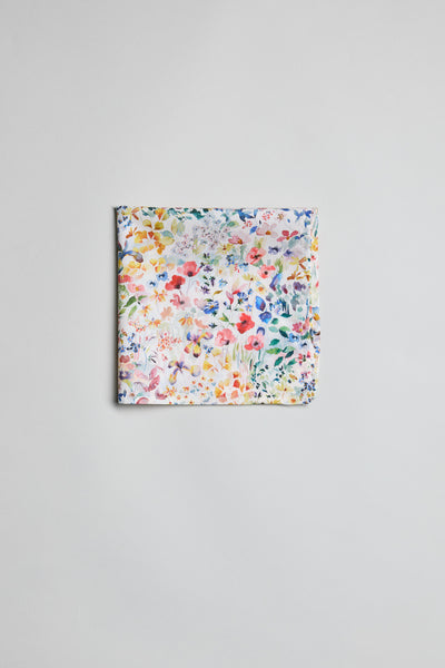 The Liberty Felda PS by Liberty is a neatly folded pocket square made from Tana Lawn cotton, showcasing a vibrant multicolored floral print on white, displayed on a plain light gray surface.