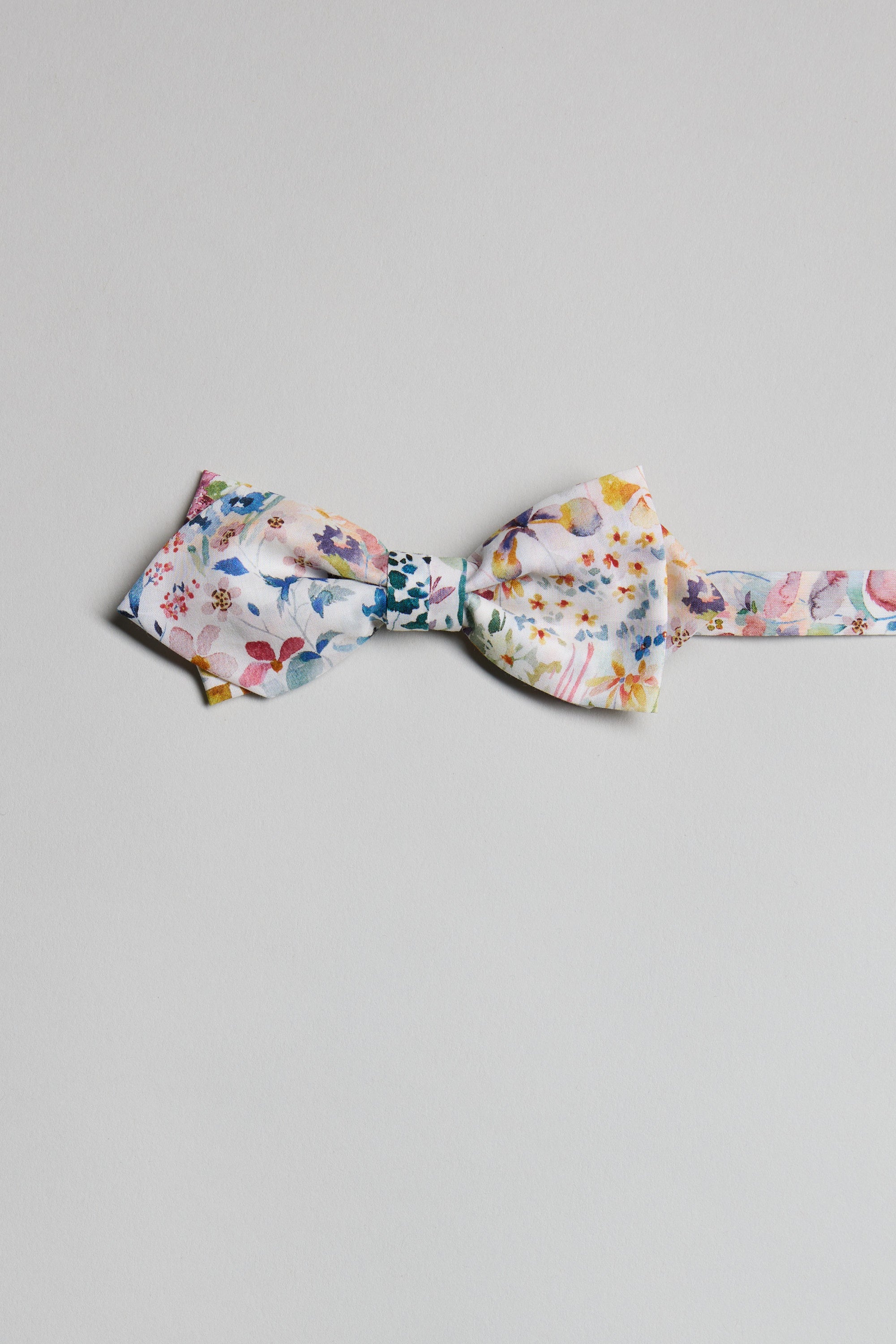 The Liberty Felda Bow Tie by Liberty, handmade in New Zealand from Tana Lawn cotton with a vibrant floral design, is shown laid flat on a light gray background.