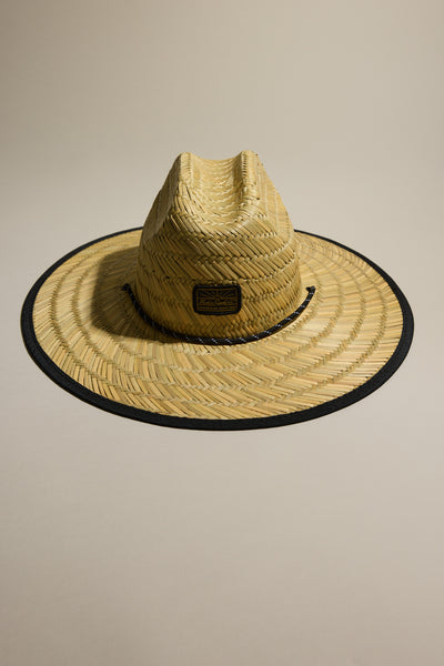 The Barkers Straw Hat by Barkers features a wide brim, black edge trim, and a rectangular front patch—your summer essential for ultimate sun protection. Displayed on a neutral background.