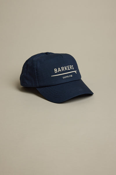 The Barkers Wave Master Cap is a navy blue snapback with "BARKERS SUPPLY CO" embroidered in white on the front, shown against a plain light grey background.