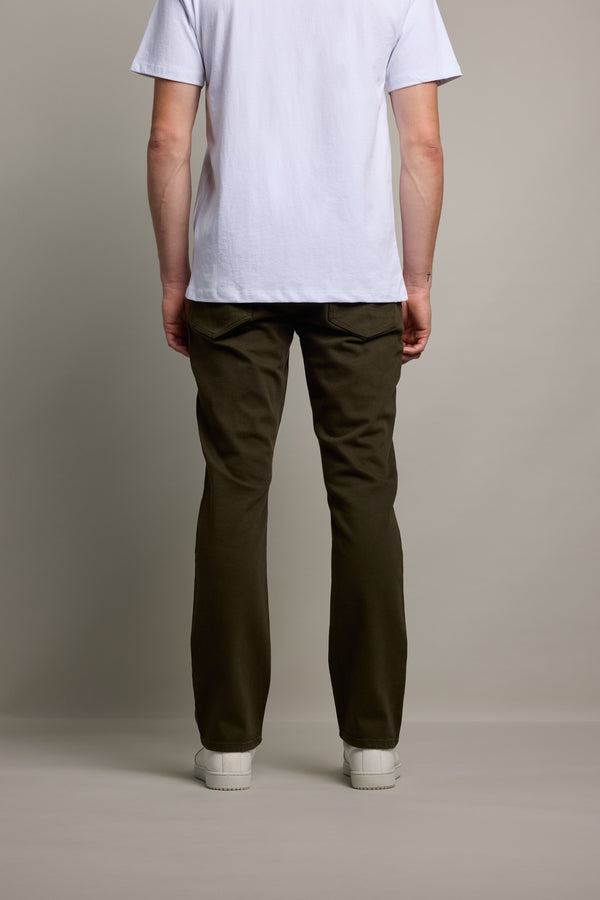 A person stands facing away from the camera in a plain white T-shirt, Barkers Wanderer Straight Coloured Jeans, and white shoes, set against a plain gray background.