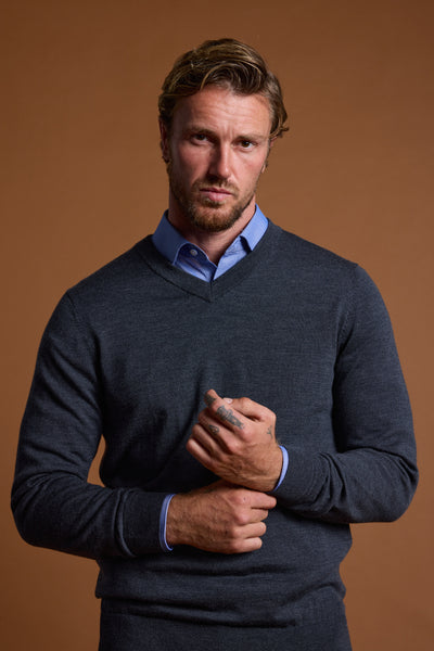 Man in Barkers Skyland ZQrx Merino Vee poses by a plain brown backdrop.