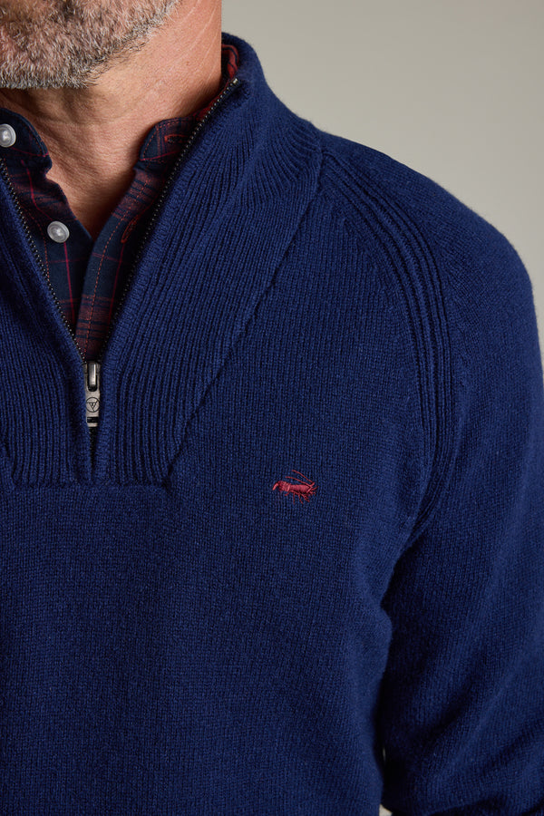 Man in Barkers Rowley Woollen 1/4 Zip navy sweater, over plaid shirt, red chest logo.