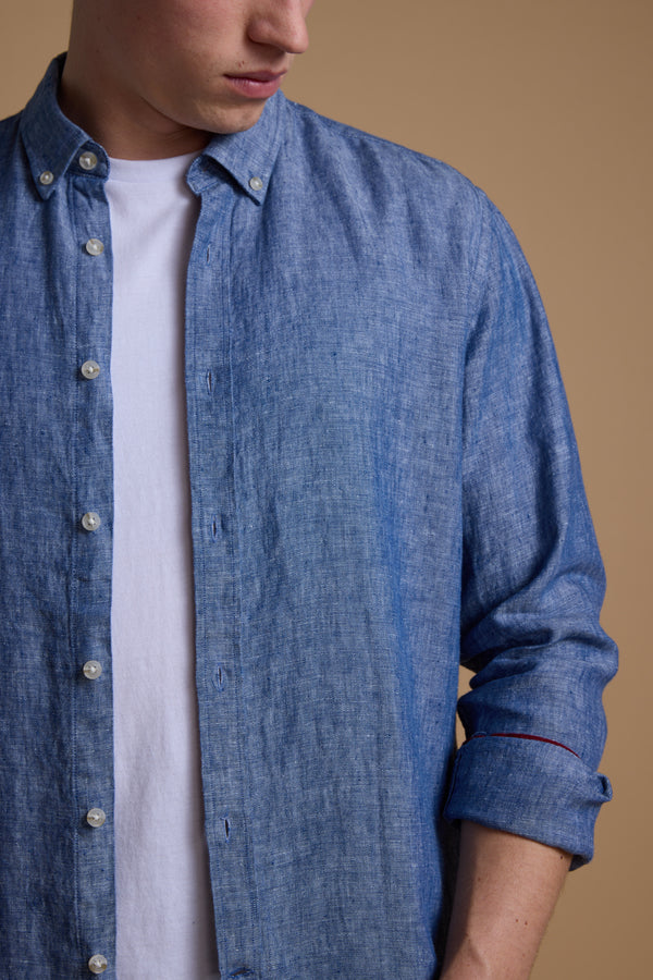 A person in a tailored fit Barkers Dorset Linen Shirt, layered over a white tee, stands against a beige background. Rolled-up sleeves show off the breathable linen; only their lower face is visible.