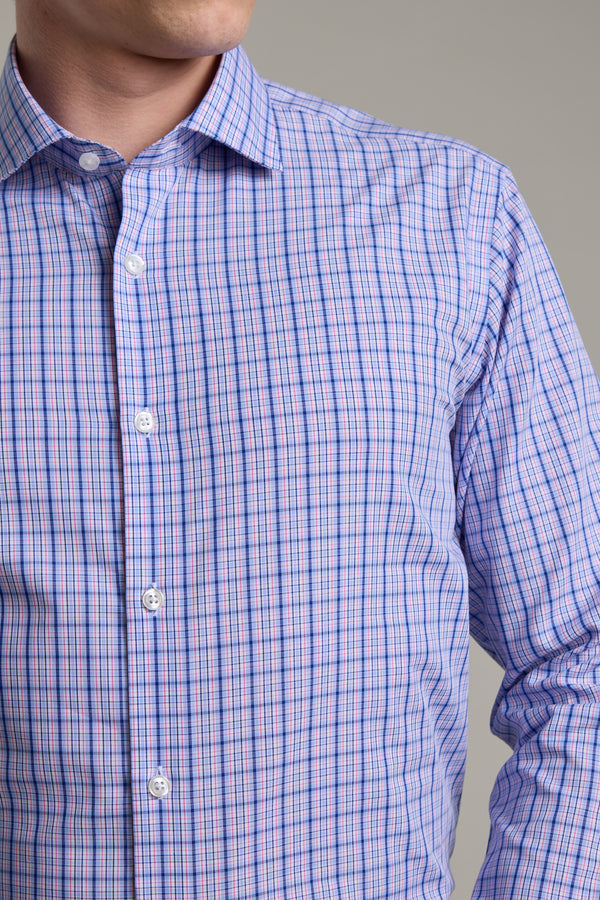 A man wears the Barkers Denton Check Business Shirt with blue and pink plaid, made from Eco Easy Care cotton. Only his upper body and part of his face are visible against a plain gray background.