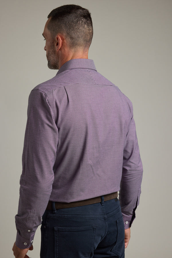 A man with short hair is seen from behind wearing a Barkers Waverly Check Business Shirt in purple, long-sleeved and tailored fit, tucked into blue pants with a brown belt against a plain background.