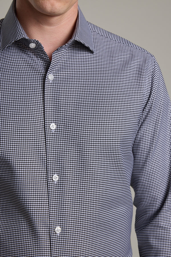 A man wears the Barkers Mitchel Check Business Shirt, a tailored fit, long-sleeve shirt featuring a small black and white check pattern, shown from shoulders to waist against a plain background.