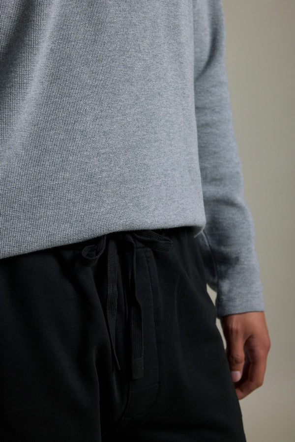 Person in a gray long-sleeve shirt and Barkers Organic Classic Print Track Pant.