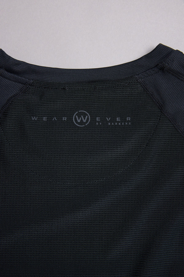 Close-up of the inside back collar of a black WearEver Pulse Tee by WearEver, featuring a circular W logo and brand text printed on quick-dry performance mesh fabric.