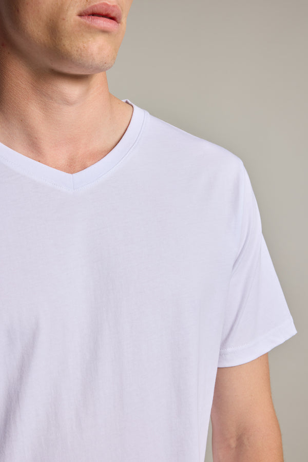 A close-up shows the lower face, neck, and upper torso of a person wearing the Barkers Organic Cotton V Neck Tee in plain white, set against a neutral background.