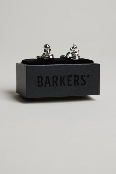 A pair of Barkers Chess Cufflinks, shaped like a pawn and knight in silver, displayed on a black Barkers box—a distinctive formal accessory for any chess lover.