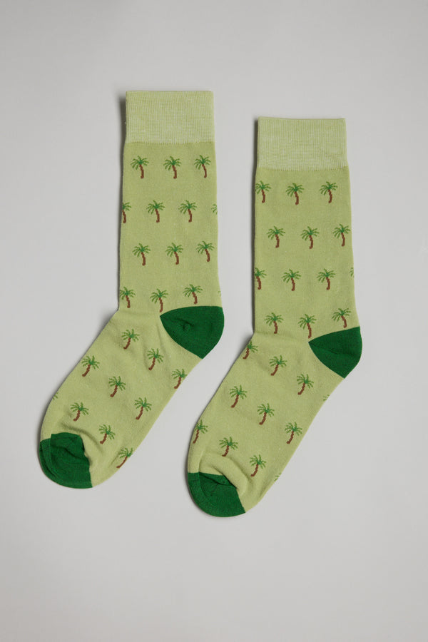 The Barkers Palm Tree Sock features light green fabric with dark green heels and toes, decorated with small palm tree patterns, shown on a plain white background.