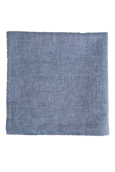 The Parisian Denim Pocket Square by Parisian is a rectangular, blue 100% cotton accessory with subtle texture and visible edge stitching, shown flat on a white background.