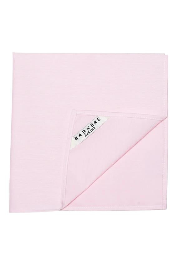 The Tribeca Pocket Square by Barkers is a neatly folded light pink accessory, featuring one turned-up corner and a "Barkers Est. 1972" label—a timeless men's piece made from 100% cotton.