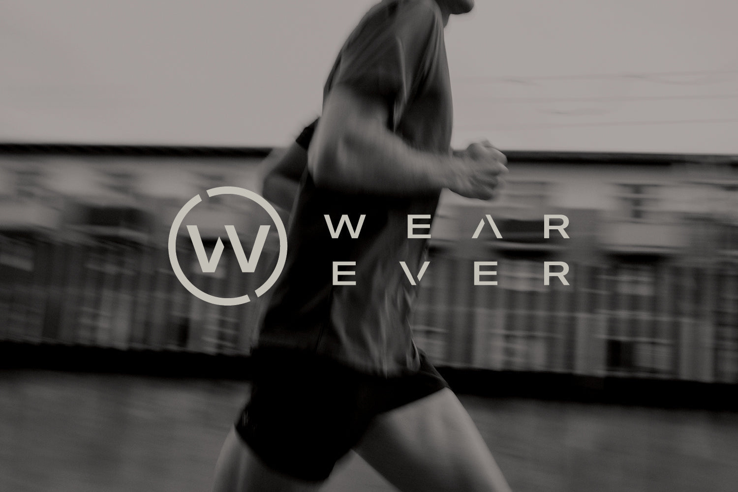 A blurred black-and-white image of a person running outdoors, with the words WEAR EVER and a circular W logo overlayed in the center.