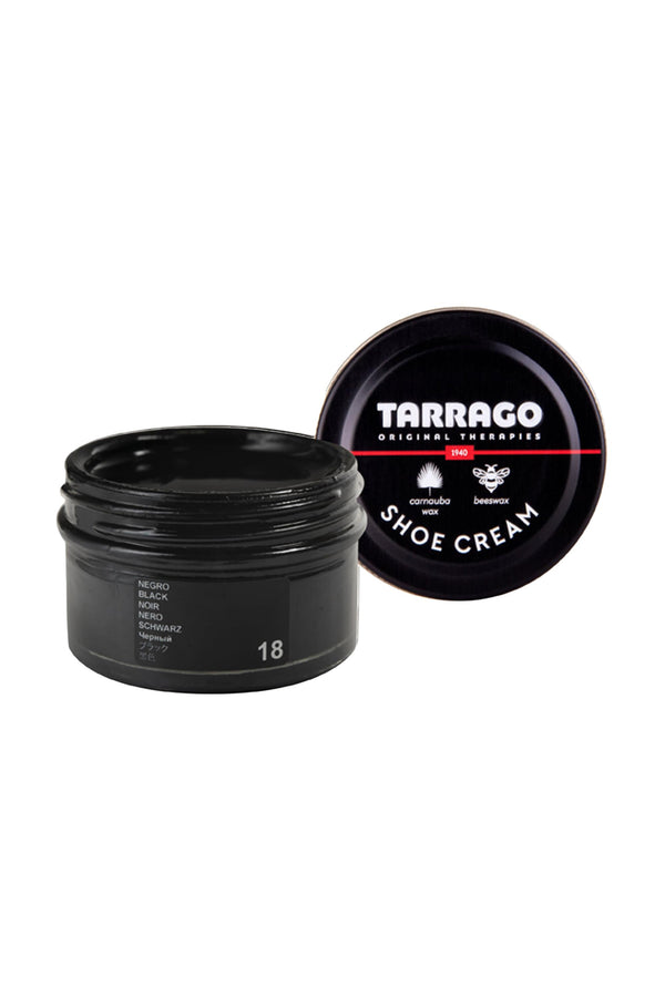 An open jar of Tarrago Shoe Cream in black sits with its branded lid beside it. The smooth, glossy cream inside, enriched with carnauba wax, nourishes and optimally shines leather.