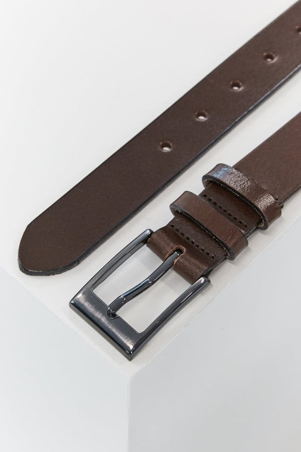 A close-up of the Frances Leather Belt by Barkers, featuring brown leather and a silver square buckle, displayed unfastened on a white surface with visible adjustment holes and pointed end. Made in New Zealand.