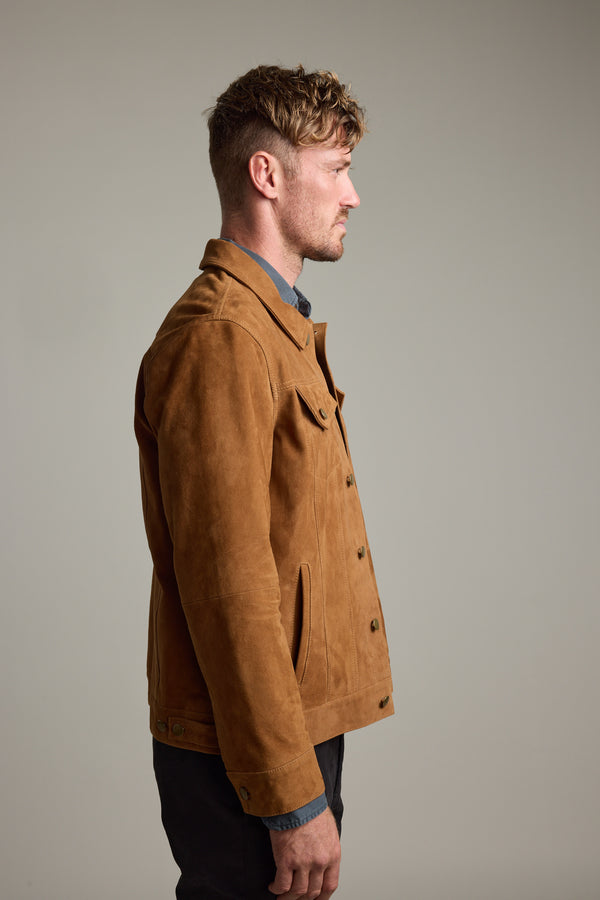 Man models Barkers Jackson Suede Trucker jacket with dark pants against a plain background.