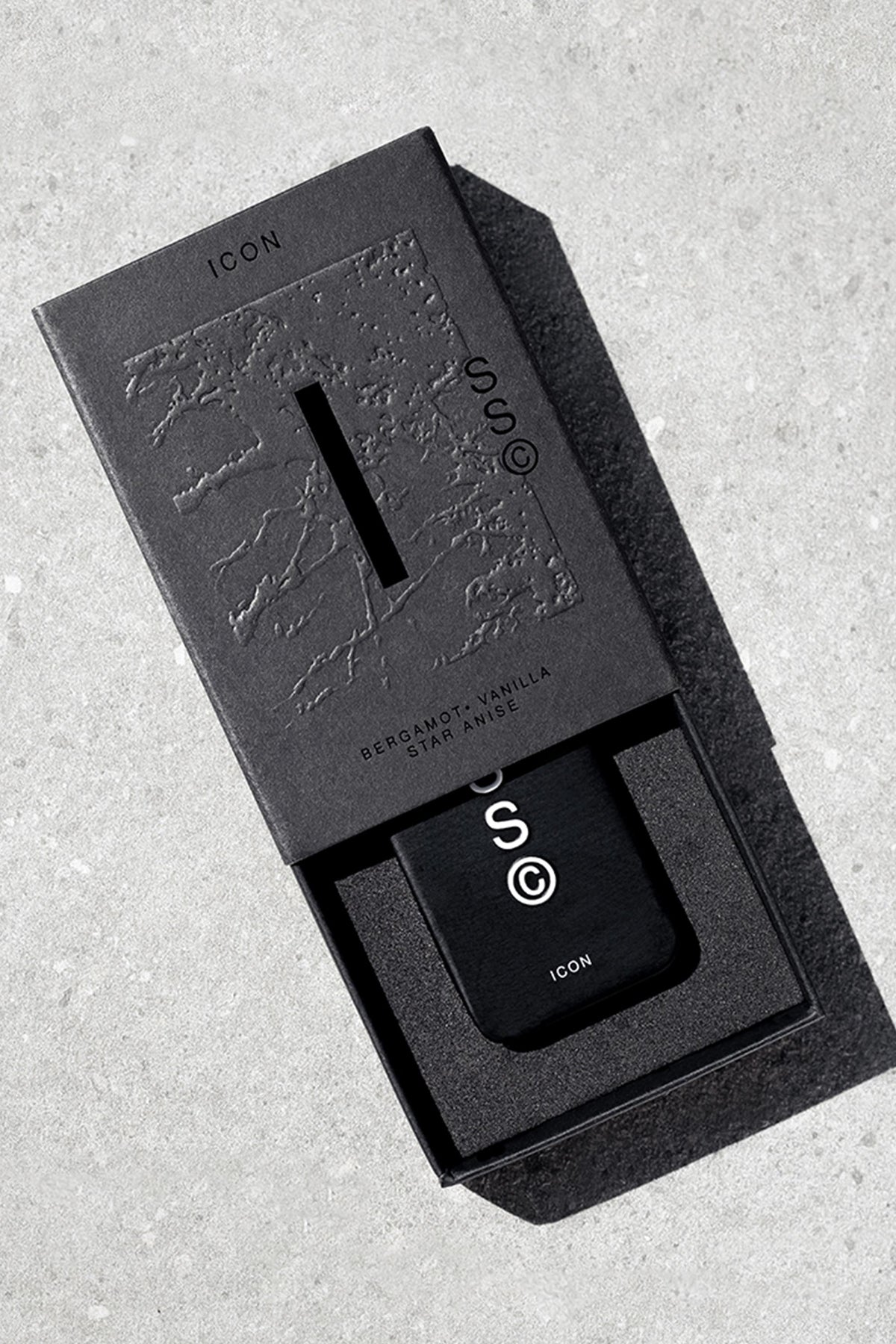 Solid State - Icon: black rectangular solid cologne in sleek, textured packaging on gray surface.