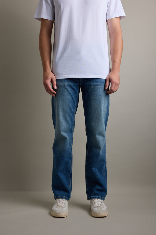 Person wearing a white t-shirt, Barkers Drifter Denim Relax Jean, and white sneakers.