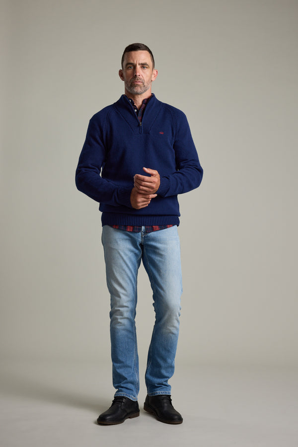 Man in Barkers Rowley Woollen 1/4 Zip, jeans, and black shoes stands against a light background.