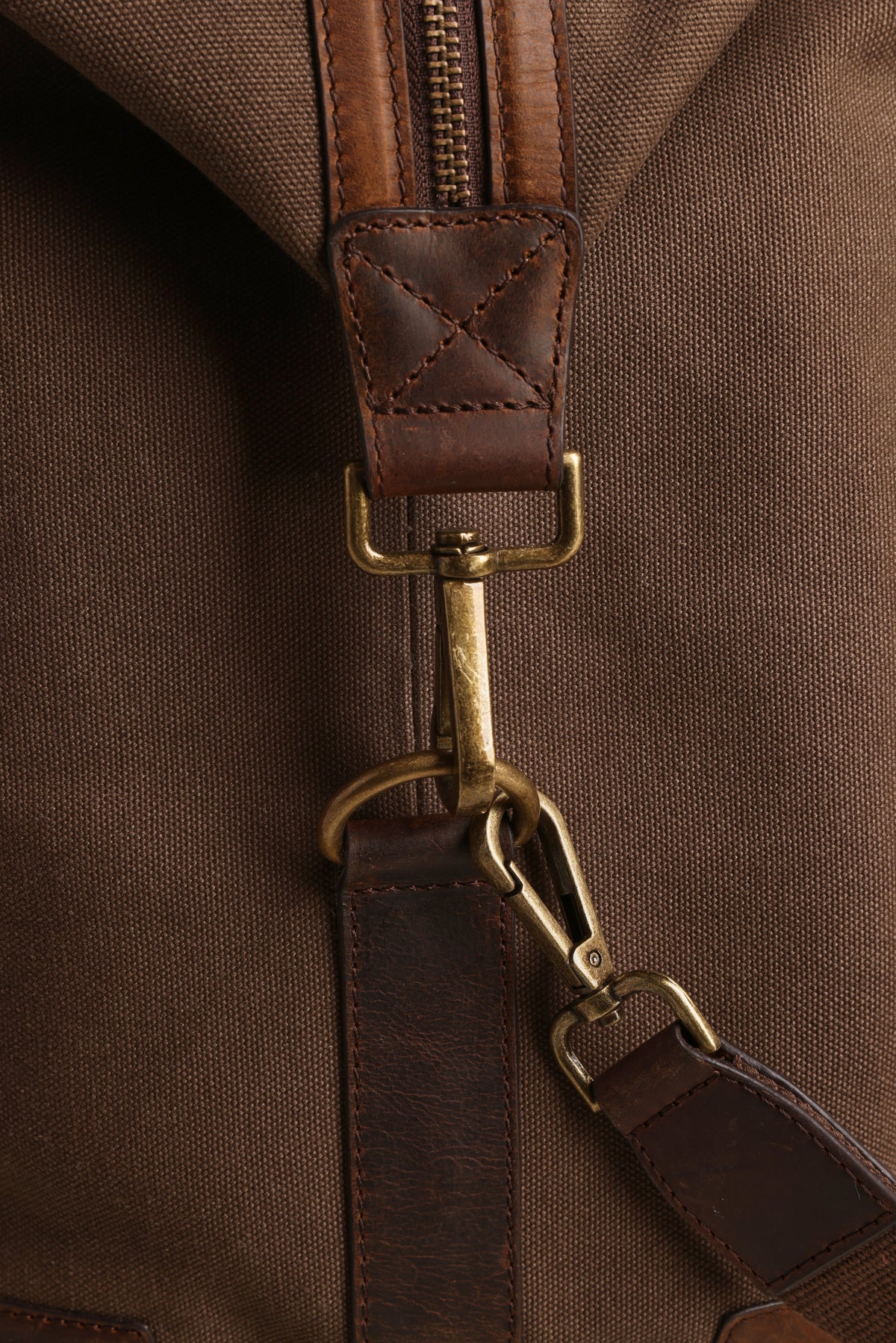 Brown leather & brass hardware on Barkers Newman Canvas Weekender, close-up of strap clasp.