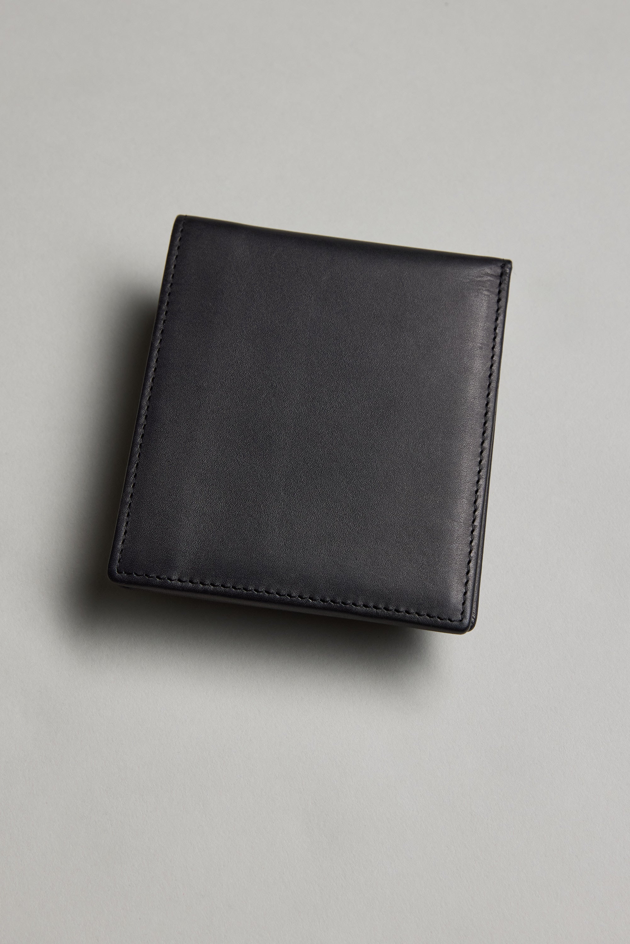 The Barkers Harris Leather Fold Wallet, in closed black leather with minimal stitching, is displayed on a light gray surface.