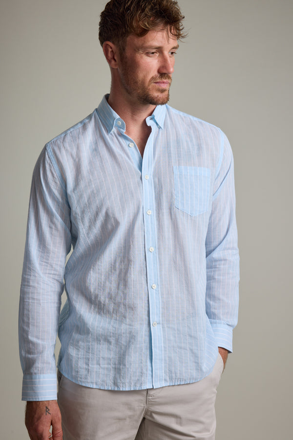 A man with short, wavy brown hair and a beard models the Barkers Russell Stripe Shirt, a 100% cotton long sleeve shirt with vertical white stripes and a chest pocket. He stands against a plain background, looking to his left.