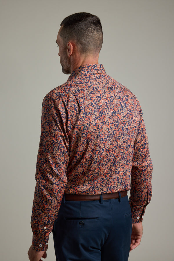 A man with short hair, seen from behind, wears a classic fit Paisley Business Shirt by Barkers, tucked into dark blue pants with a brown belt. He stands against a plain neutral background.