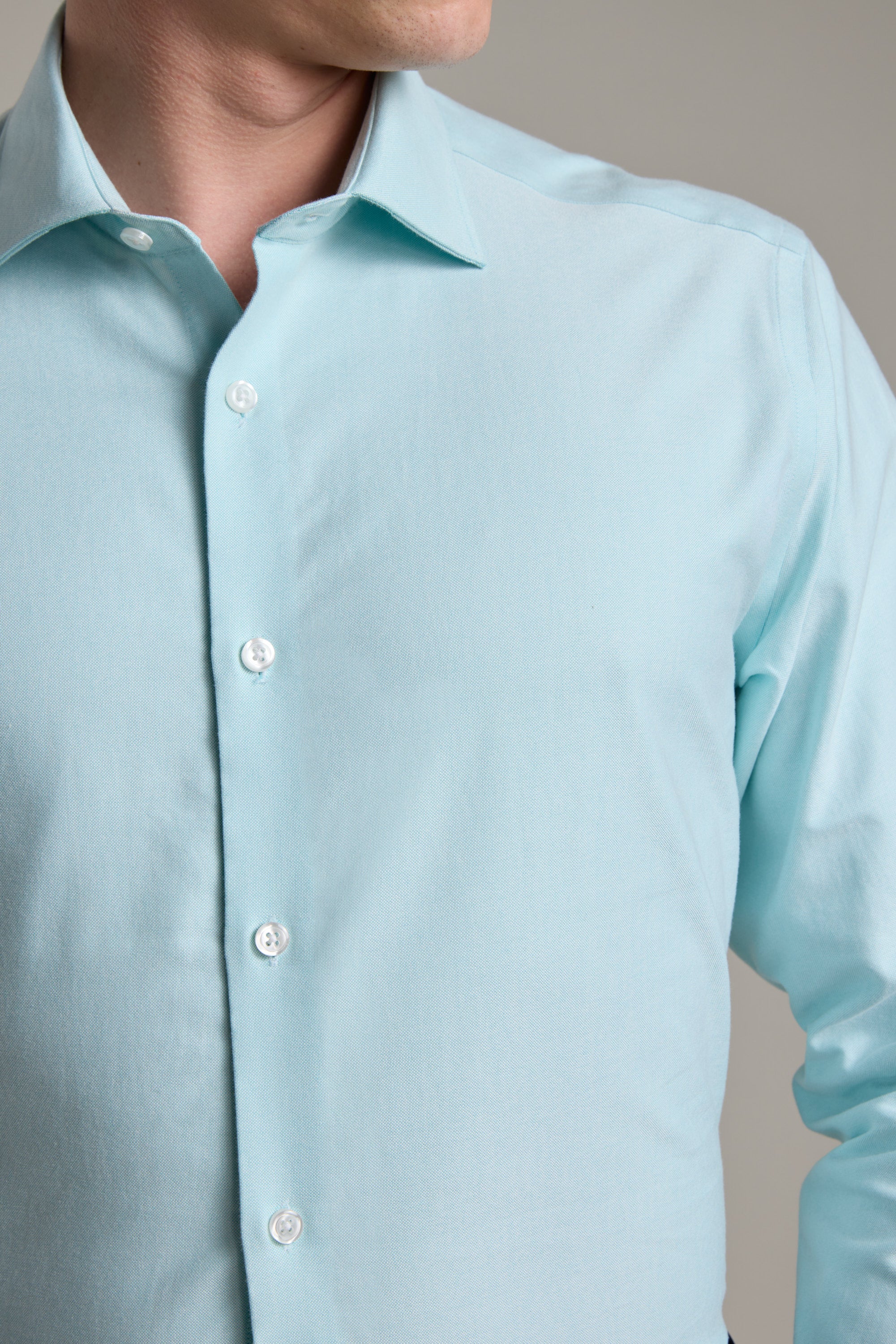 A man wears the Barkers Edgar Texture Business Shirt in light blue cotton with white buttons, shown from shoulders to waist and facing slightly to the side. His face is partially out of frame.