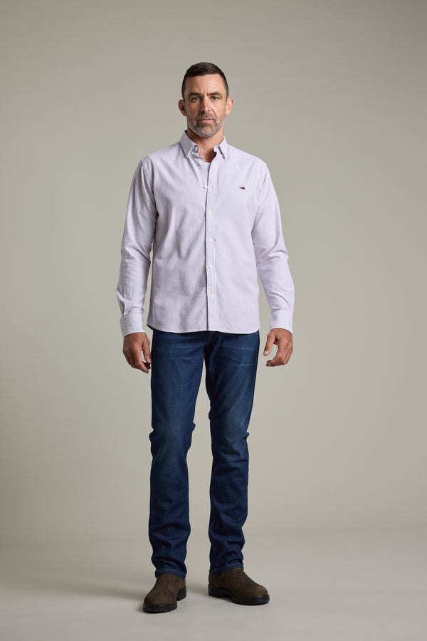 Man in Barkers Maynard Oxford Stripe Shirt, blue jeans, and brown boots against a plain background.