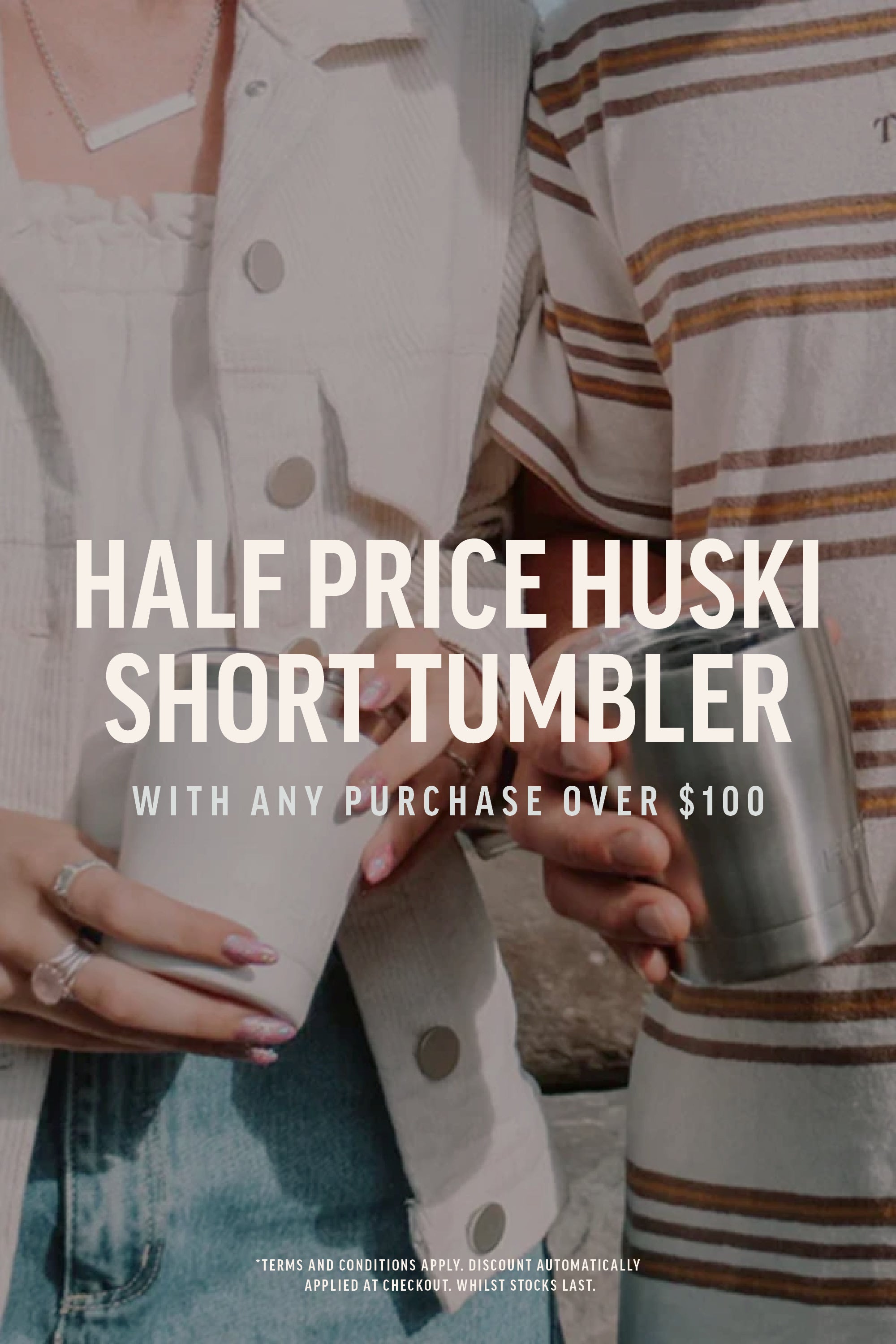 Two people hold Huski Short Tumbler 2.0 by Huski—one with a white tumbler, the other with a silver one. Text reads: Half price Huski Short Tumbler 2.0 with any purchase over $100.