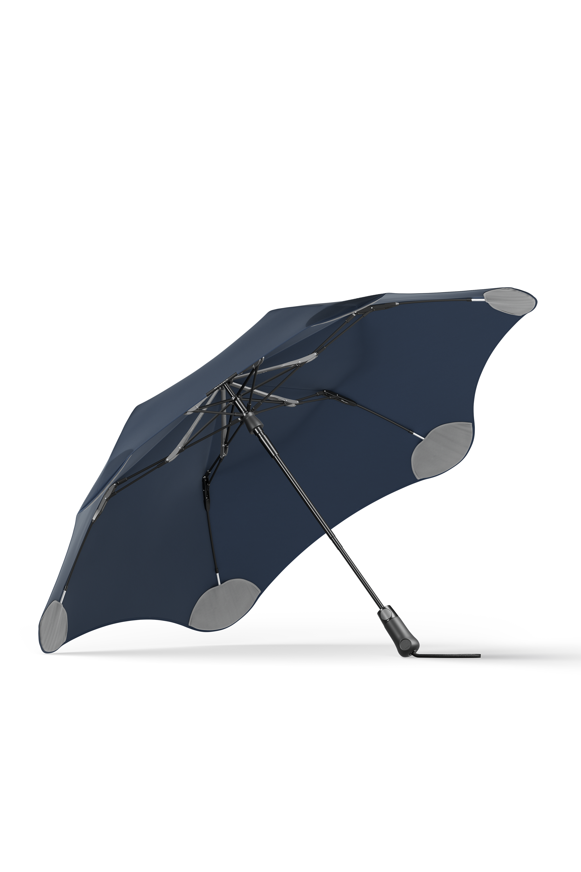 The Blunt Metro Umbrella by Blunt is shown open and angled to the side against a white background, featuring a dark blue color, aerodynamic design with rounded edges, and reinforced gray tips.