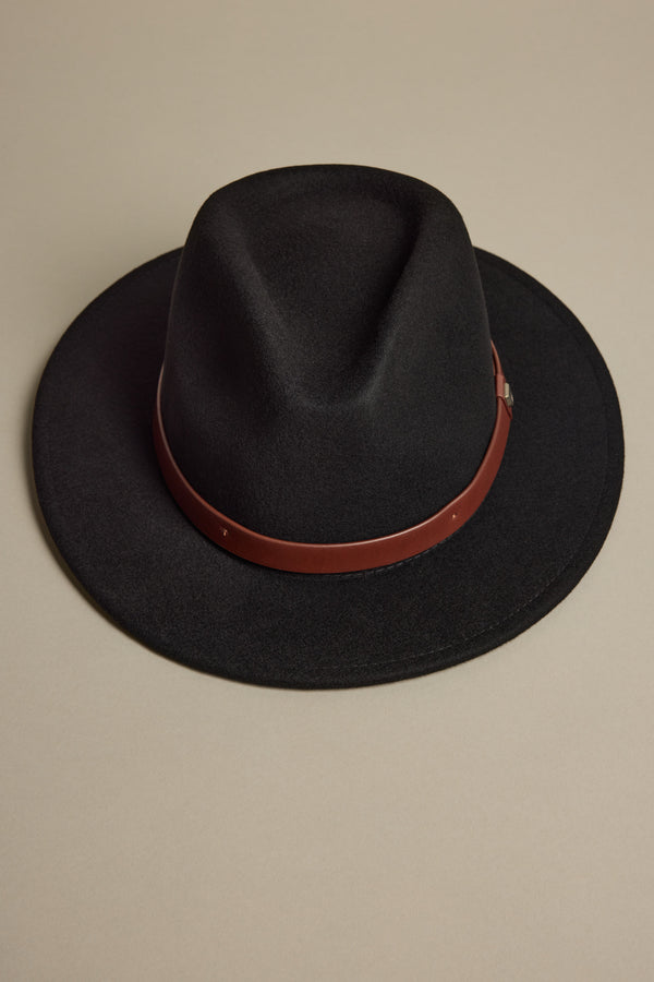 The Brixton Messer Fedora Hat by Brixton is a black wool felt fedora with a brown leather band around the crown, shown on a plain beige background.