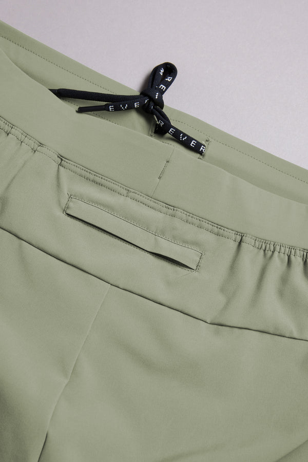 Close-up of light green WearEver Cadence Short featuring an elastic waistband, black drawstring bow, and horizontal back pocket. Made from lightweight, breathable fabric with a 5-inch inseam for comfort.