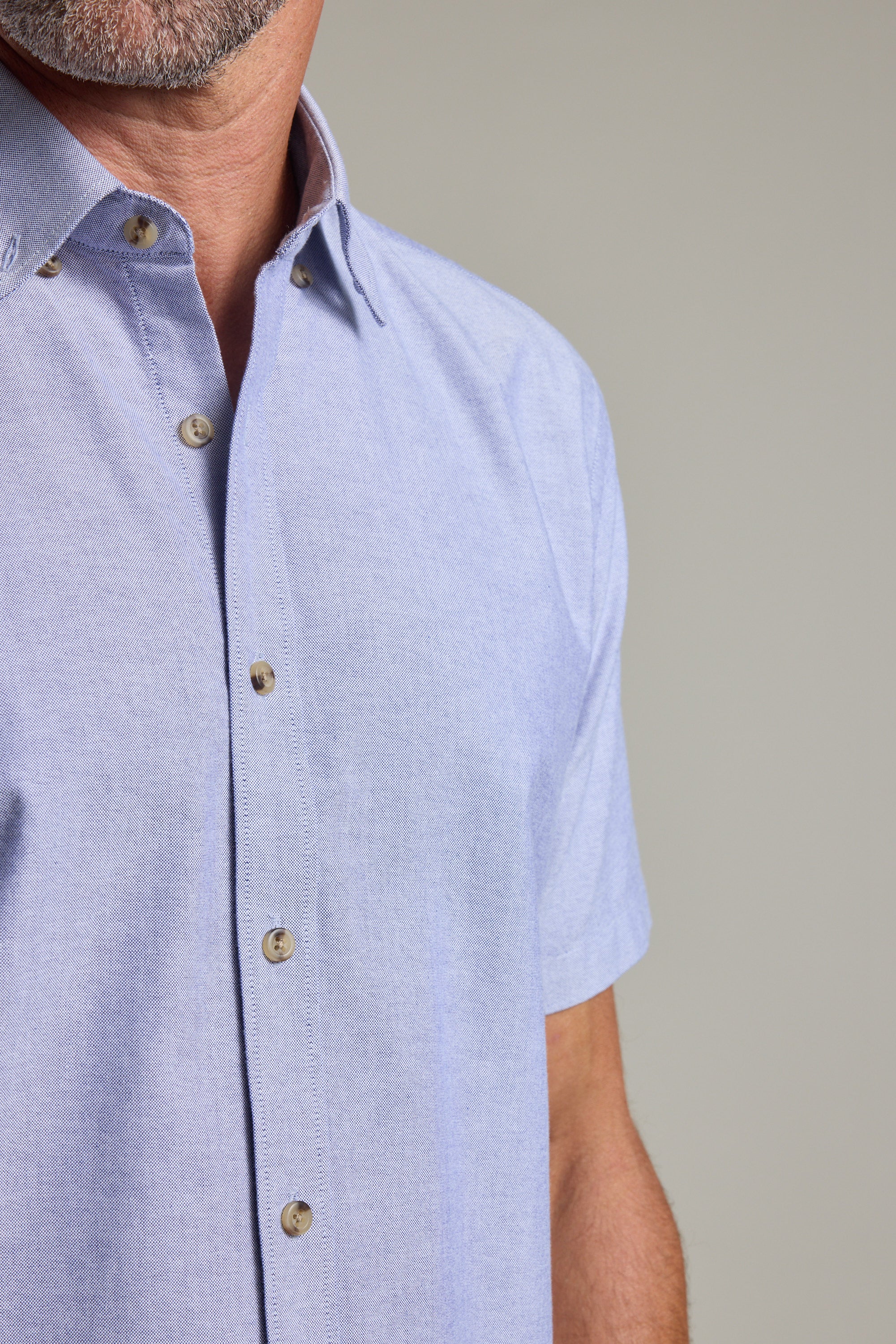 A man wears the Barkers Archer Oxford Shirt in light blue with a button-down collar.
