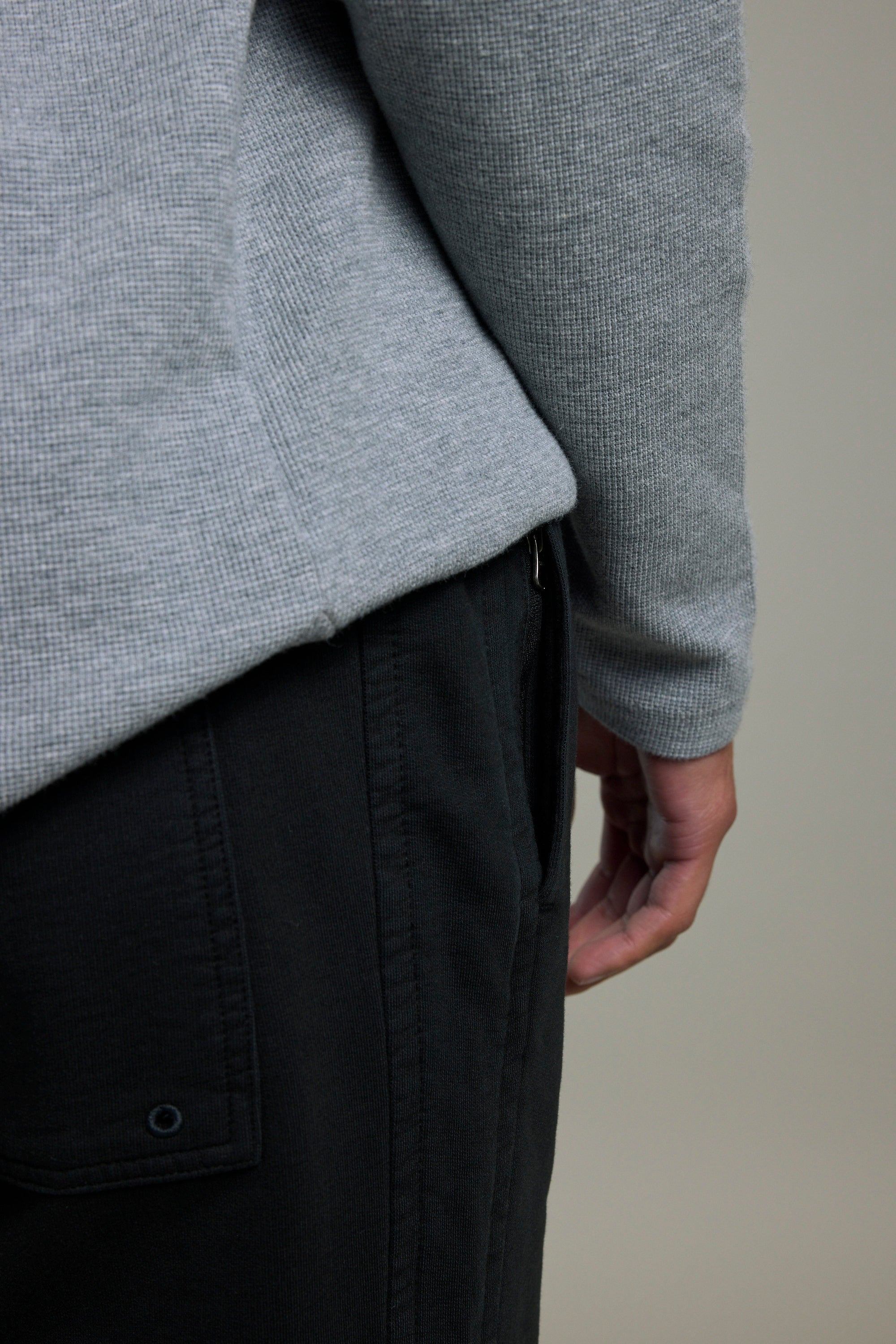Person in a grey shirt and Barkers Organic Classic Print Track Pant, hand by their side.