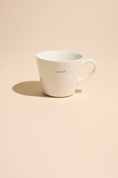 Other Bucket Mug - Genius stands out on a beige background—a bold statement piece for any space.