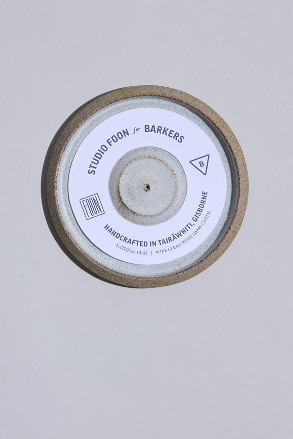 The Studio Foon Incense Dish by Other is a handcrafted round ceramic plate from New Zealand, featuring a natural clay edge, white center, and Gisborne clay origin text—ideal for use as an incense dish.