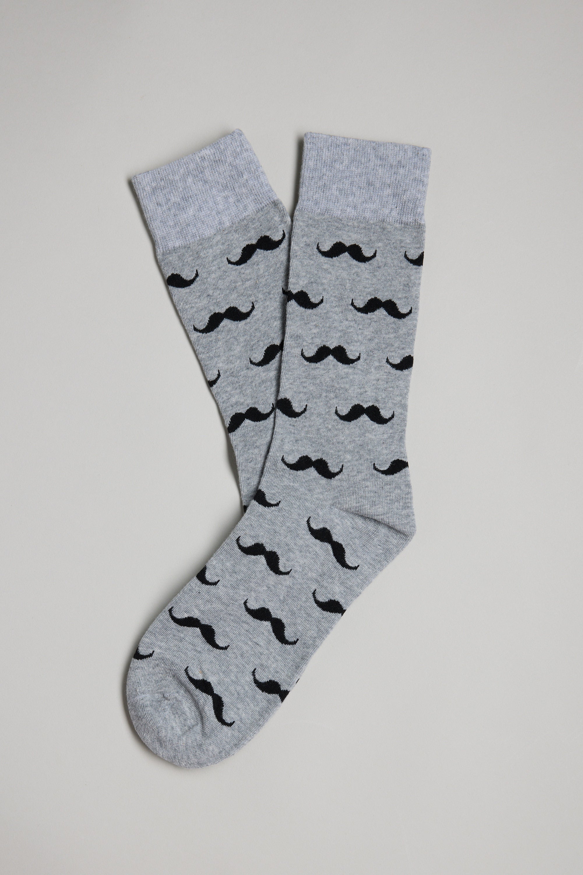 A pair of Barkers Moustache Socks in gray with light gray cuffs and a repeating black mustache pattern, laid out on a white surface—fun for Christmas gifting or as a quirky Secret Santa present.